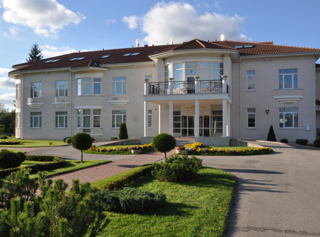 Elegant Elite clinic building with garden on a sunny day.