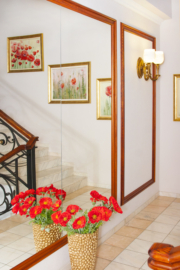 Eesti vanima ja edukaima viljatusravikliiniku trepikoja seinpeegel, mille eest on vaas lilledega.